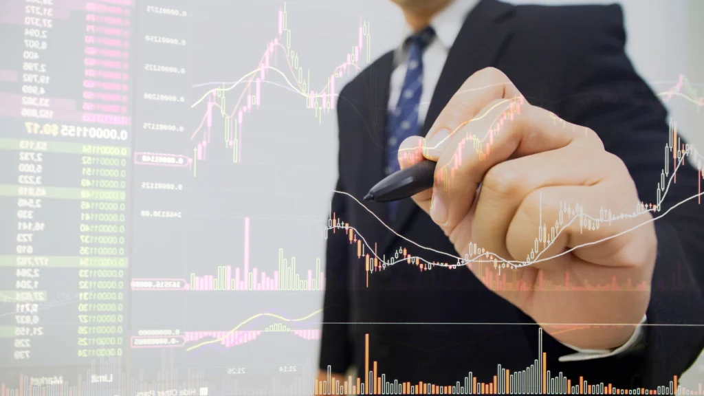 landing_page_share_banner-1 – PU Prime | More Than Trading businessman holding pen pointed on trading interface