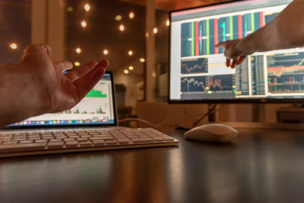 day traders discussing about trading charts data on desktop and tablet