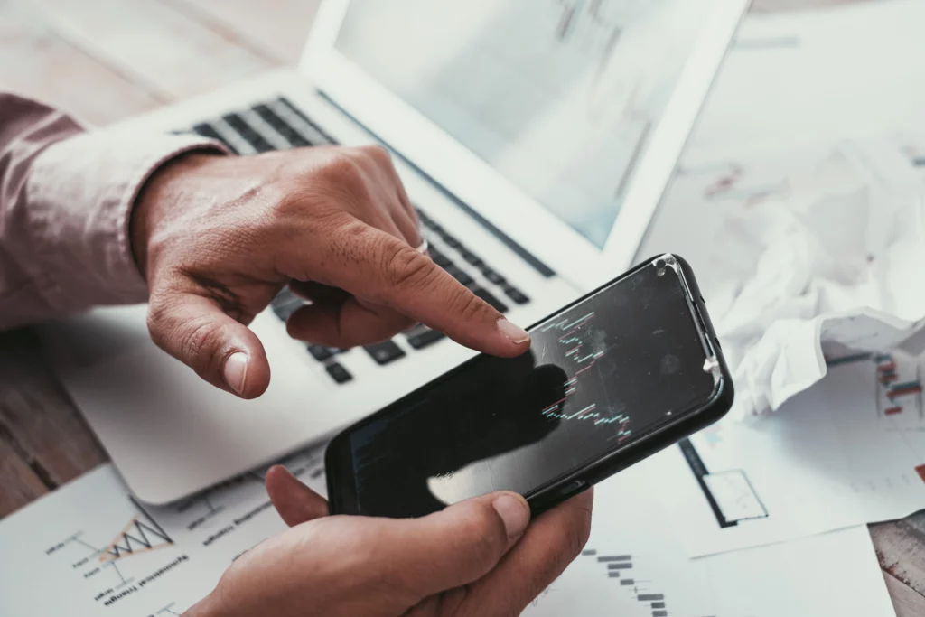 trader-looking-stock-market-chart-on-trading-app – PU Prime | More Than Trading trader looking stock market chart on trading app