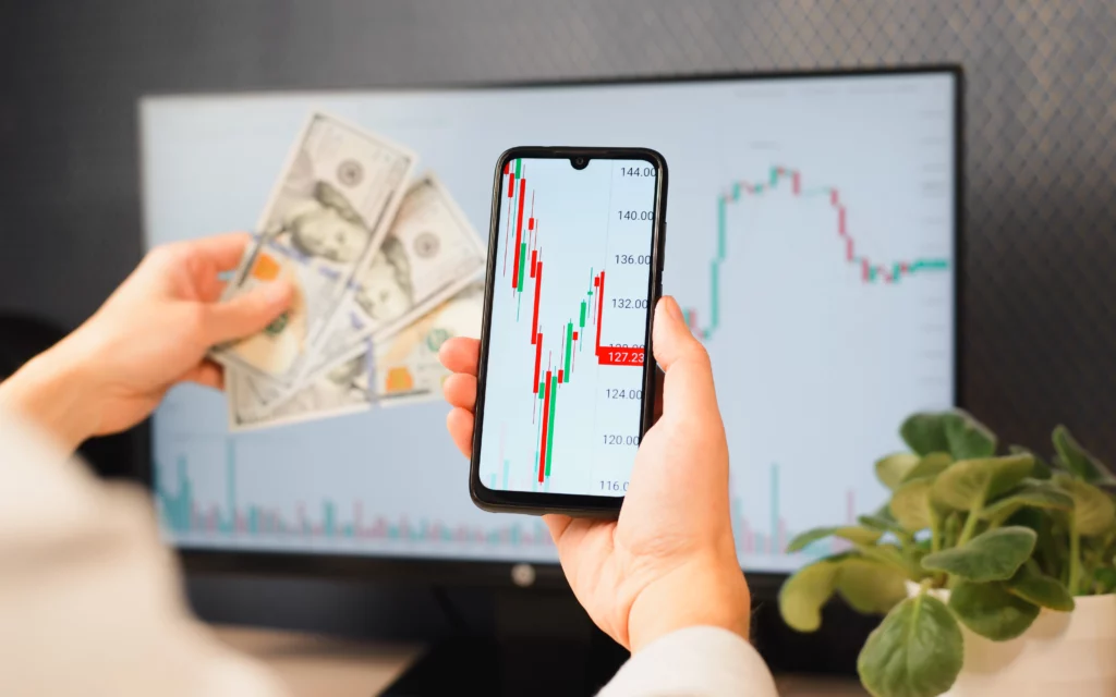 mobile-copy-trading-app-showing-trading-signals-in-front-of-a-monitor-screen – PU Prime | More Than Trading mobile copy trading app showing trading signals in front of a monitor screen